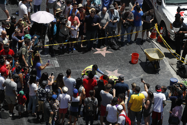Street artist puts dozens of new Trump Walk of Fame stars in place